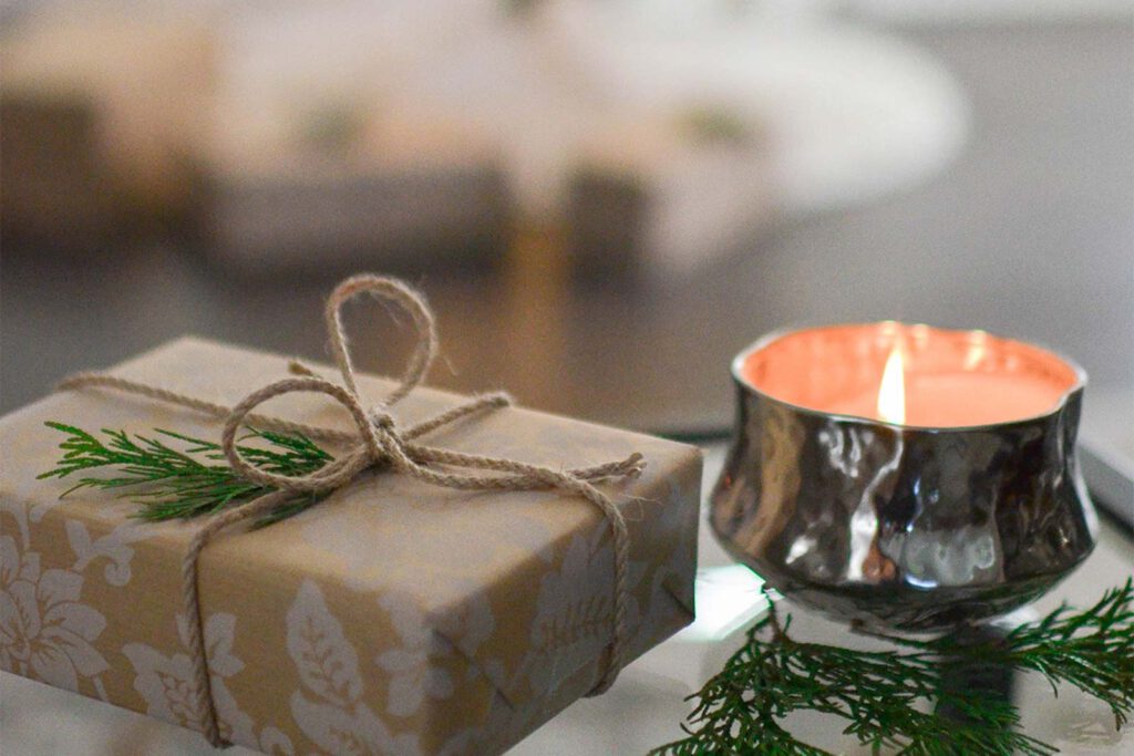 Close up view of a lit candle and small gift